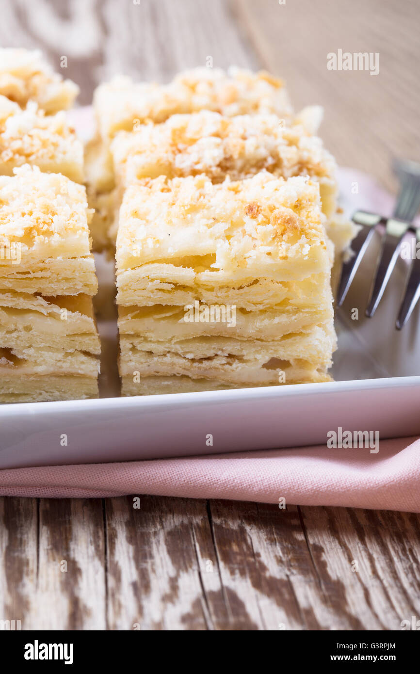Torte fatte in casa a Napoleone, pasta sfoglia crema pasticcera torta sul tavolo in legno, stile rustico Foto Stock