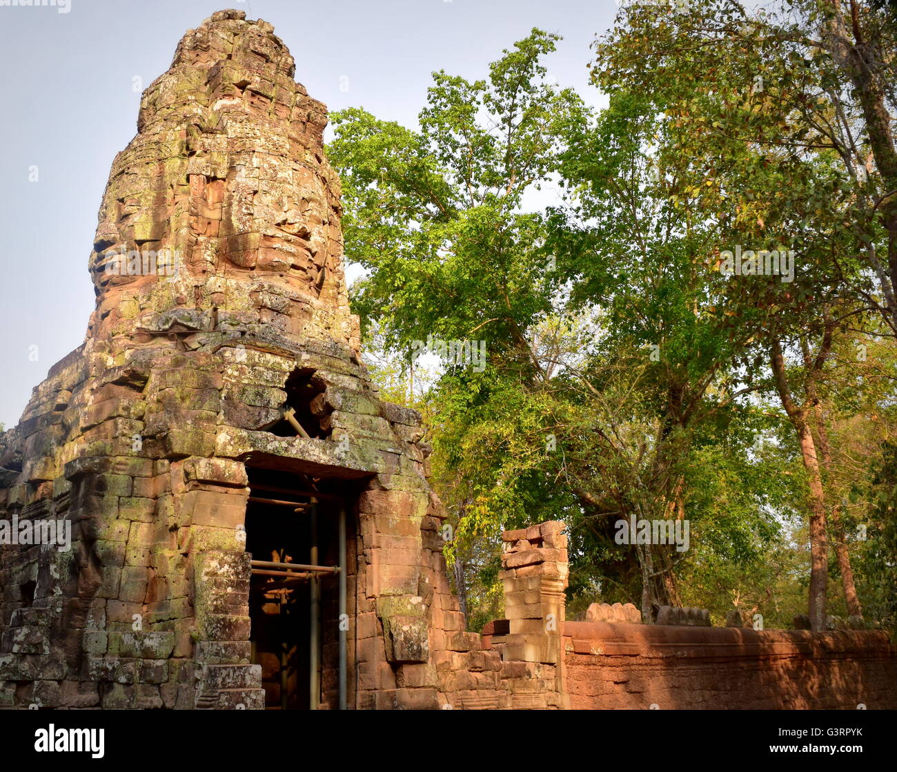 Angkor Ta Promh cancello principale custodito da facce di Buddha nella giungla della Cambogia Foto Stock