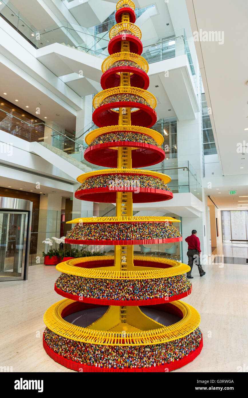 Un albero di Natale fatto di migliaia di personaggi Lego in un edificio per uffici lobby. Foto Stock