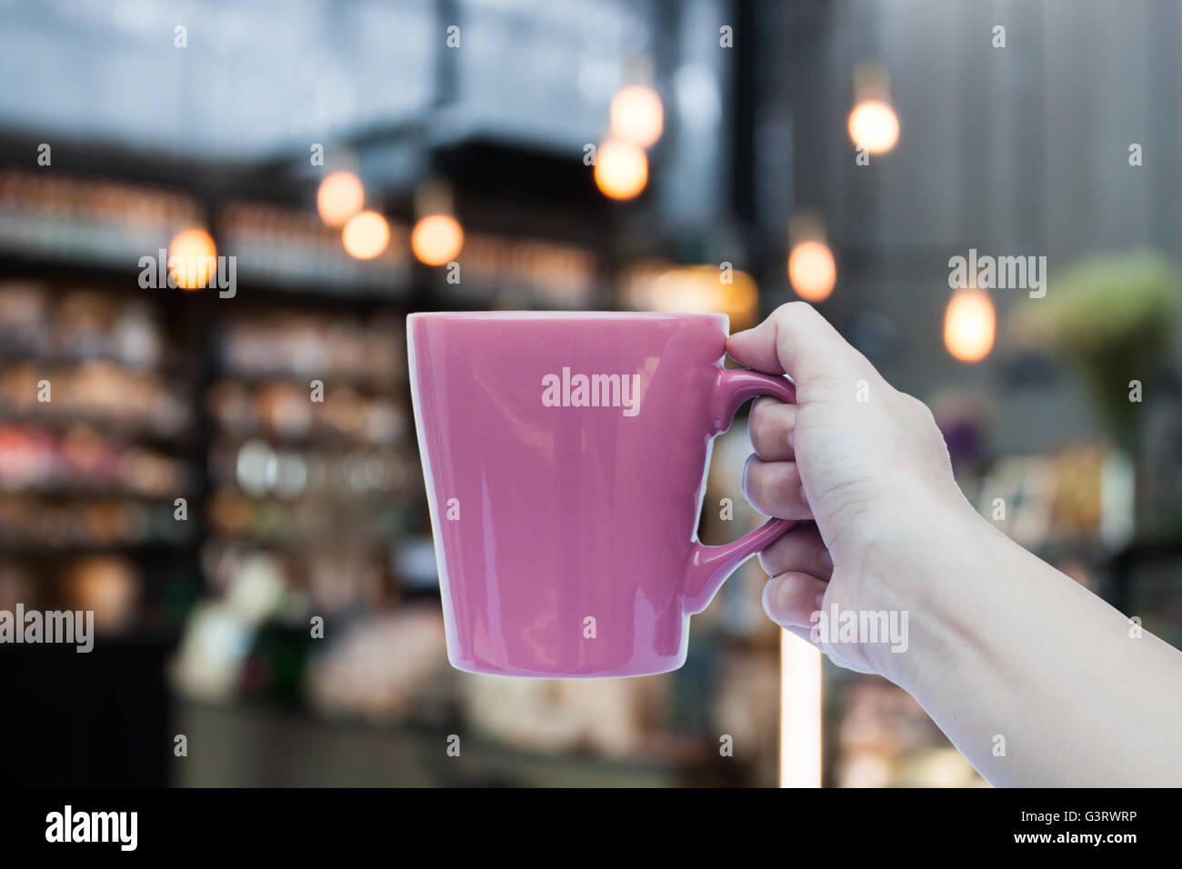 Donna mano azienda tazza da caffè sul coffee shop sfondo sfocato, stock photo Foto Stock