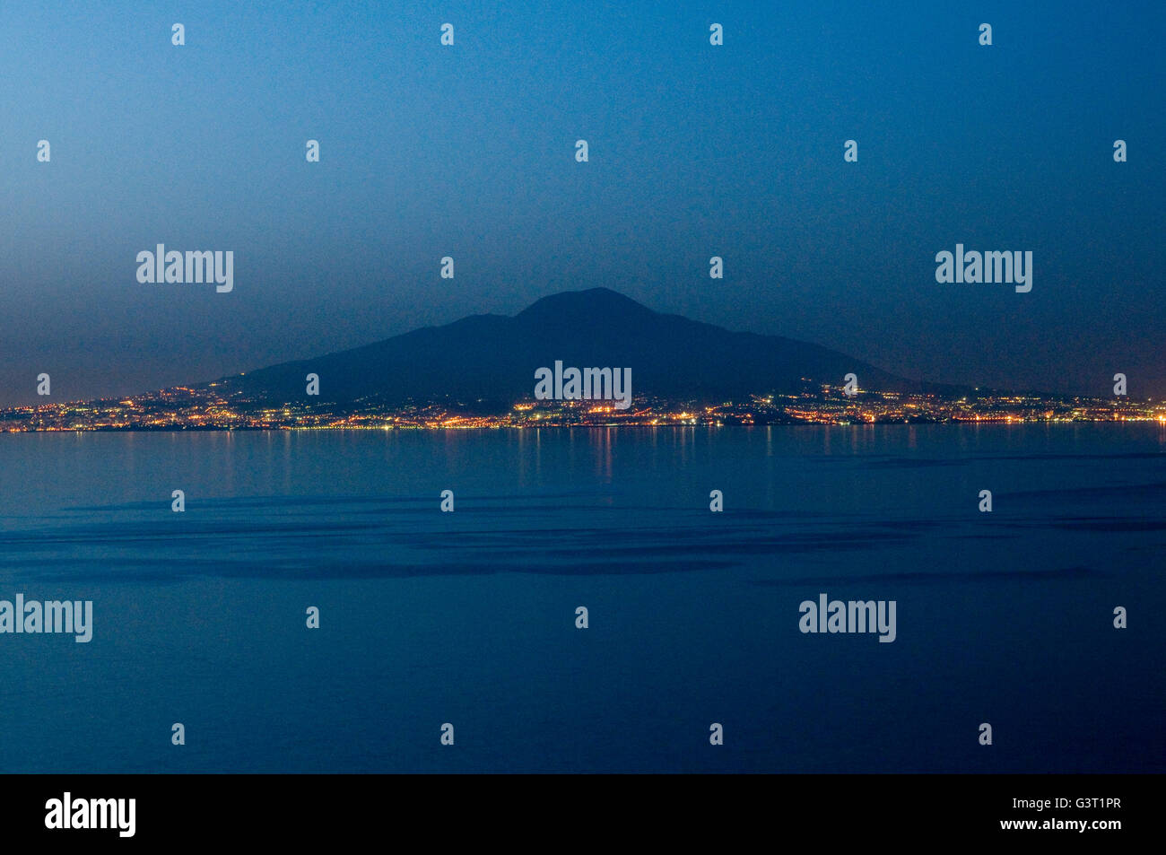 La presenza incombente del vulcano Vesuvio visto da Sorrento e sulla baia di Napoli, Italia al crepuscolo Foto Stock