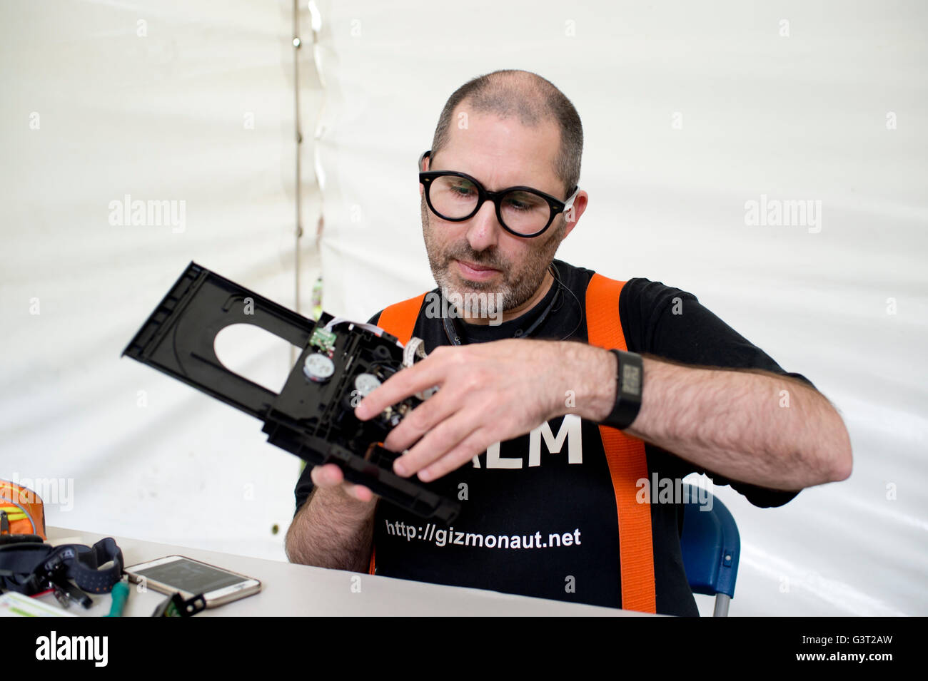 Riavviare il progetto . Un uomo che indossa una maglietta dicendo "calma" risolve la rottura di un lettore dvd, Foto Stock