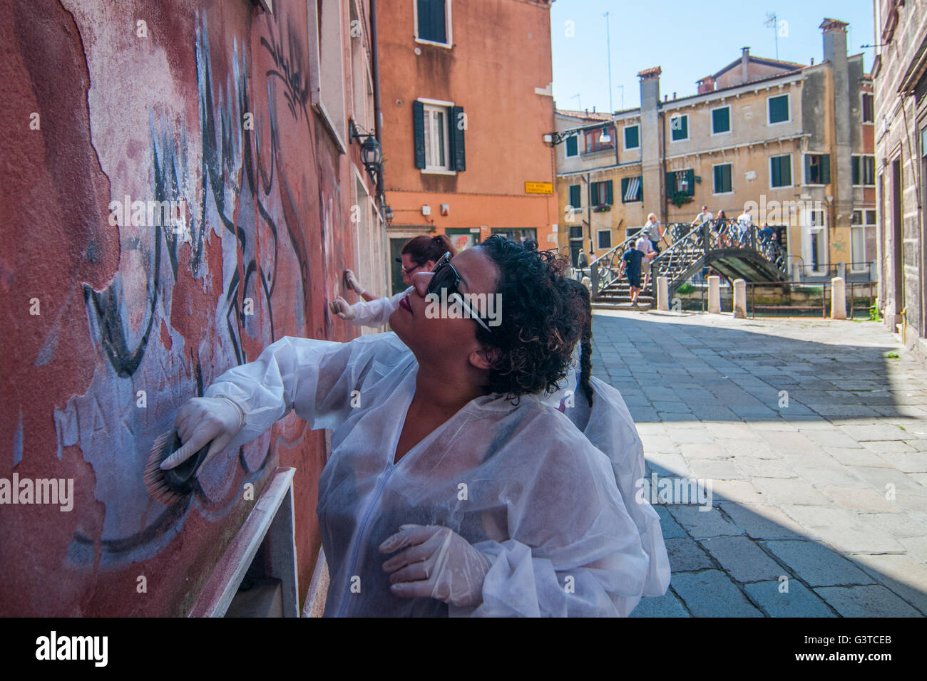 Venezia, Italia. Il 15 giugno, 2016. Uno studente americano pulisce una parete con un pennello su Giugno 15, 2016 a Venezia, Italia. L'associazione 'Masegni e nizioleti' è il tentativo di pulire le pareti dei palazzi che sono rovinate da graffiti, coinvolgendo anche alcuni studenti americani. Come per la licenza per questa immagine: si prega di contattarci via e-mail a sales@xianpix.com o una chiamata 44 (0)207 1939846 per prezzi e condizioni del diritto d'autore. Primo utilizzo solo, solo uso editoriale, tutti repros pagabile, NO ARCHIVIAZIONE. © risveglio/Xianpix Credito: Massimiliano Donati/risveglio/Alamy Live News Foto Stock