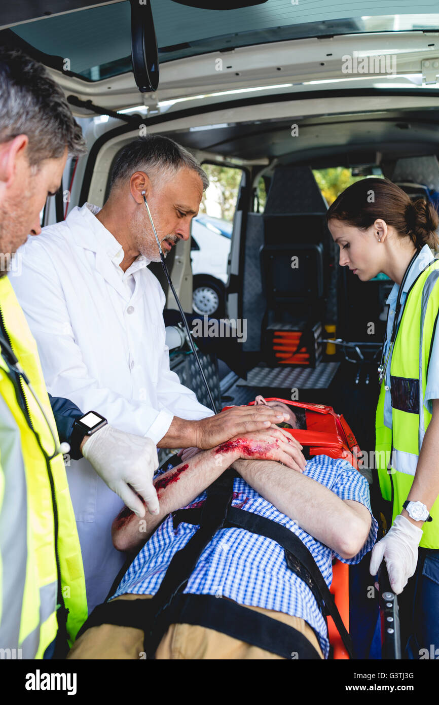 Ambulanza uomini prendersi cura dei feriti sulla barella con medico Foto Stock
