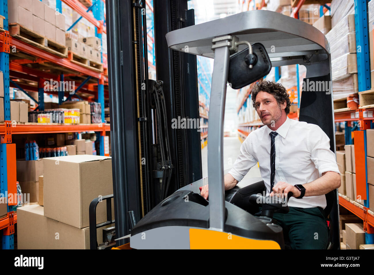 Responsabile di Magazzino utilizzando un carrello elevatore a forche Foto Stock