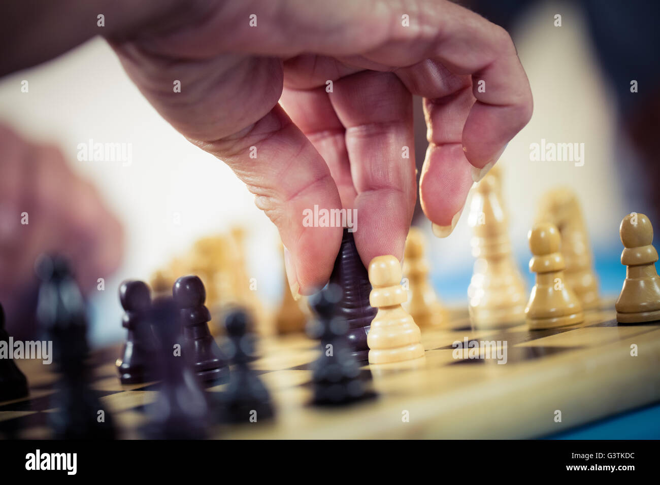 Close up di mani giocando a scacchi Foto Stock