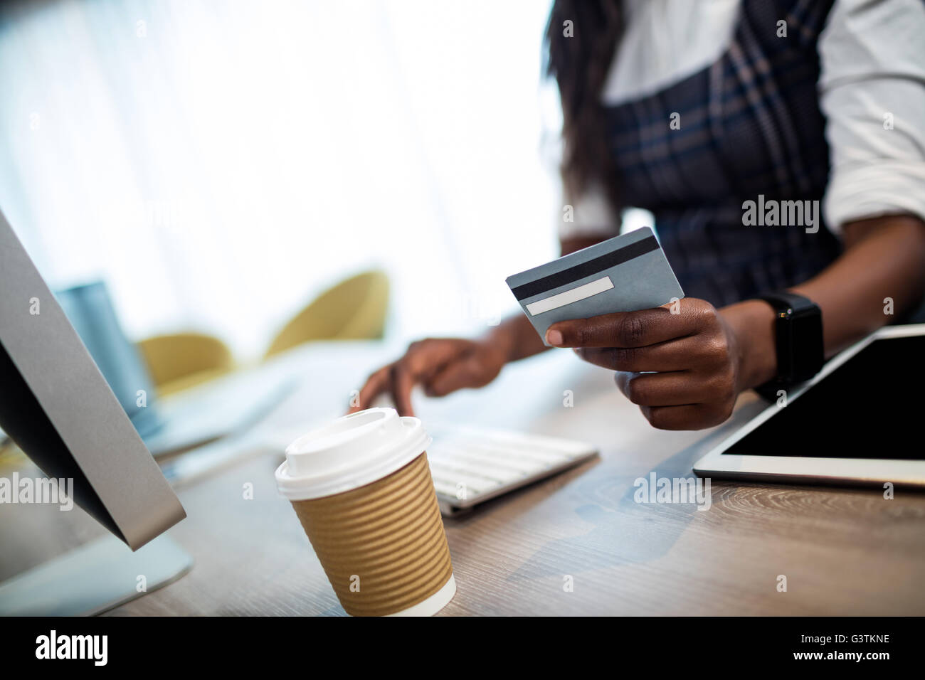 Business donna tenendo la carta di credito e la digitazione sul computer Foto Stock