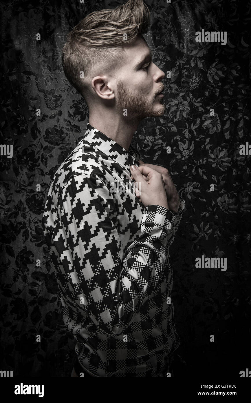 Ritratto in studio di un barbuto giovane uomo in nero e una camicia bianca. Foto Stock