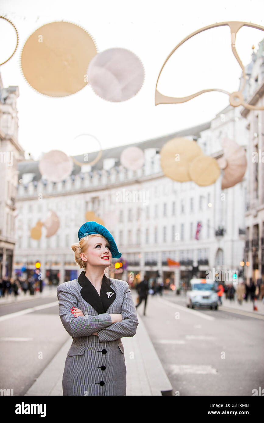 Un elegante giovane donna vestita in stile anni trenta capi di abbigliamento  in attesa di un taxi su Regent Street a Londra Foto stock - Alamy