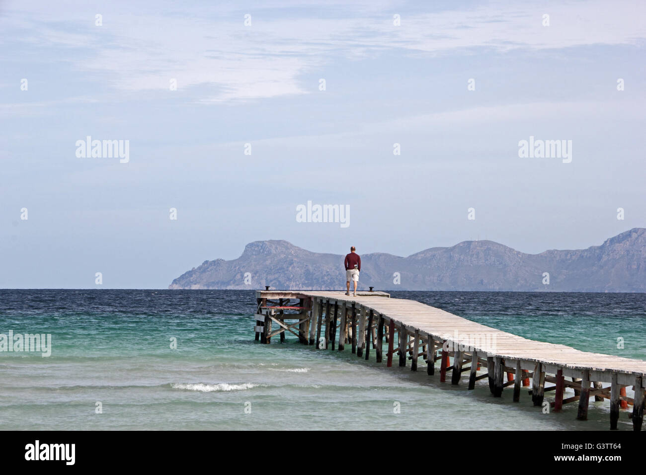 L'uomo stava in piedi alla fine del molo, guardando verso il mare Foto Stock