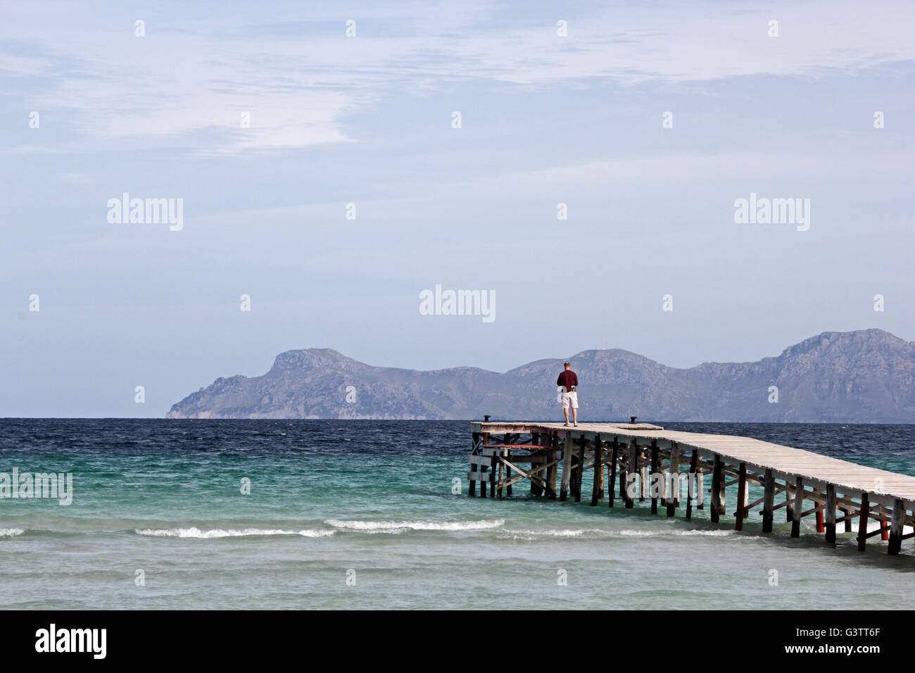 L'uomo stava in piedi alla fine del molo, guardando verso il mare Foto Stock