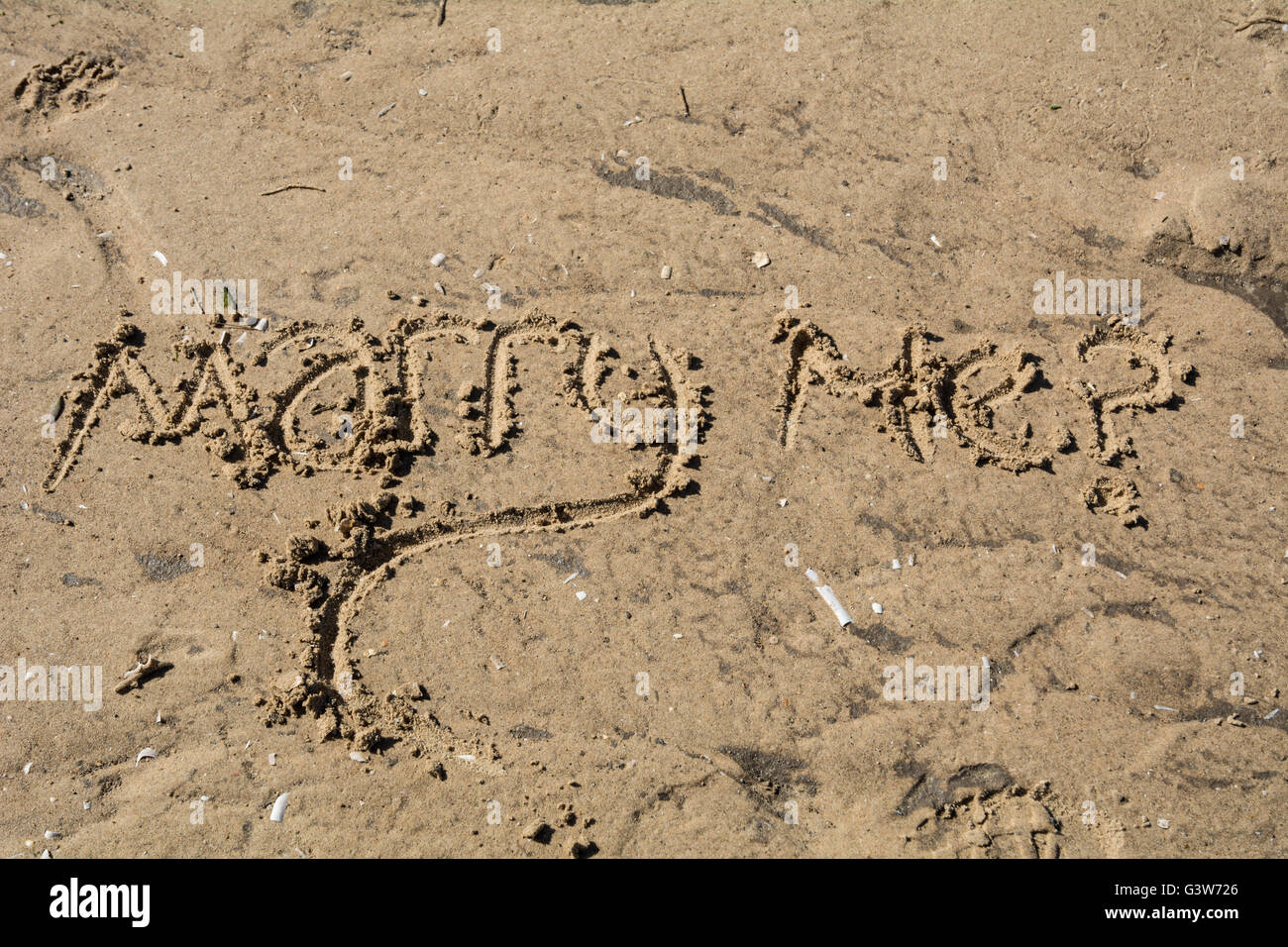 'Marry me?' scritto nella sabbia. Foto Stock