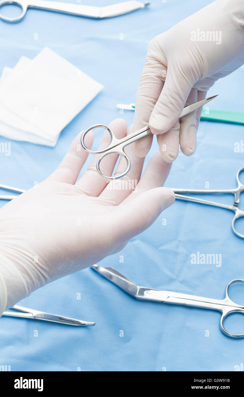 Close-up di infermiere passando le forbici per il chirurgo Foto