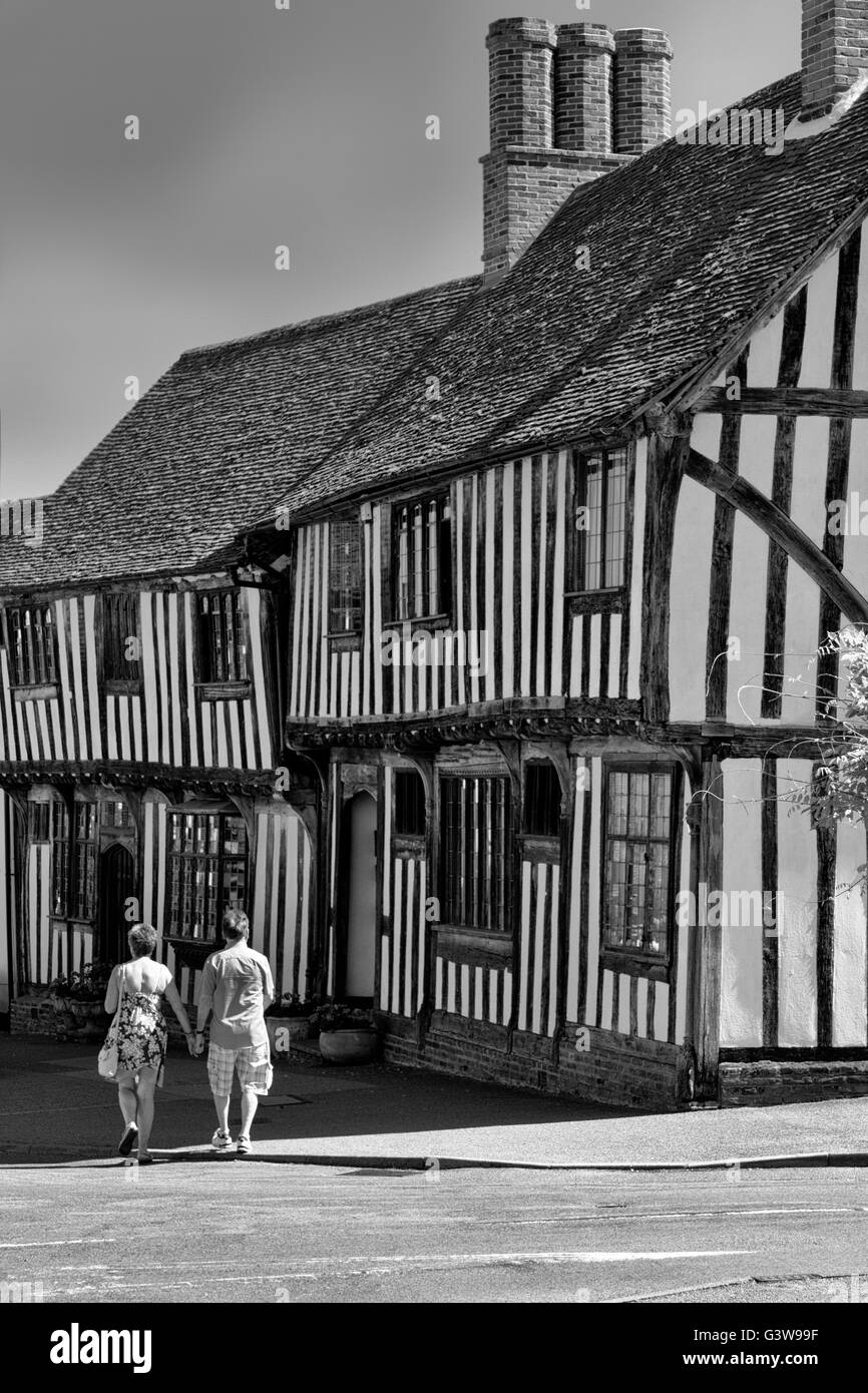 I turisti a piedi passato storico case con travi di legno, Church Street, Lavenham, Suffolk, Regno Unito Foto Stock