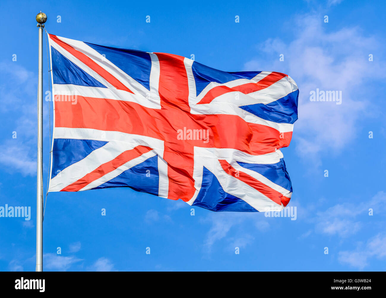 Union Jack flag del Regno Unito di Gran Bretagna e Irlanda del Nord, volare su un palo contro il cielo blu. Foto Stock