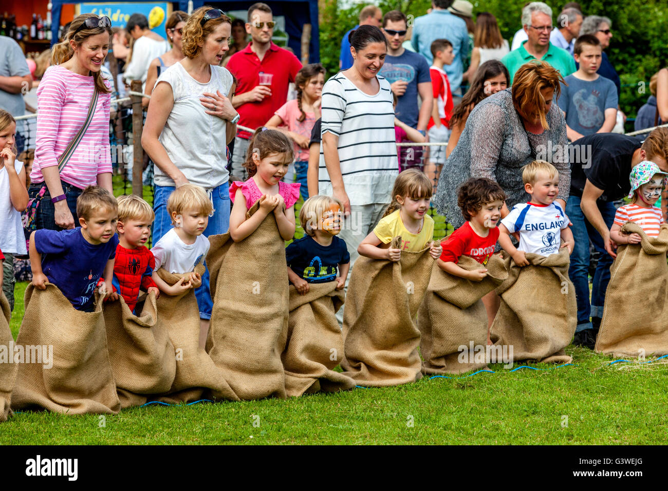 I bambini in gara un sacco tradizionale gara presso la Fiera medievale di Abinger, Surrey, Regno Unito Foto Stock