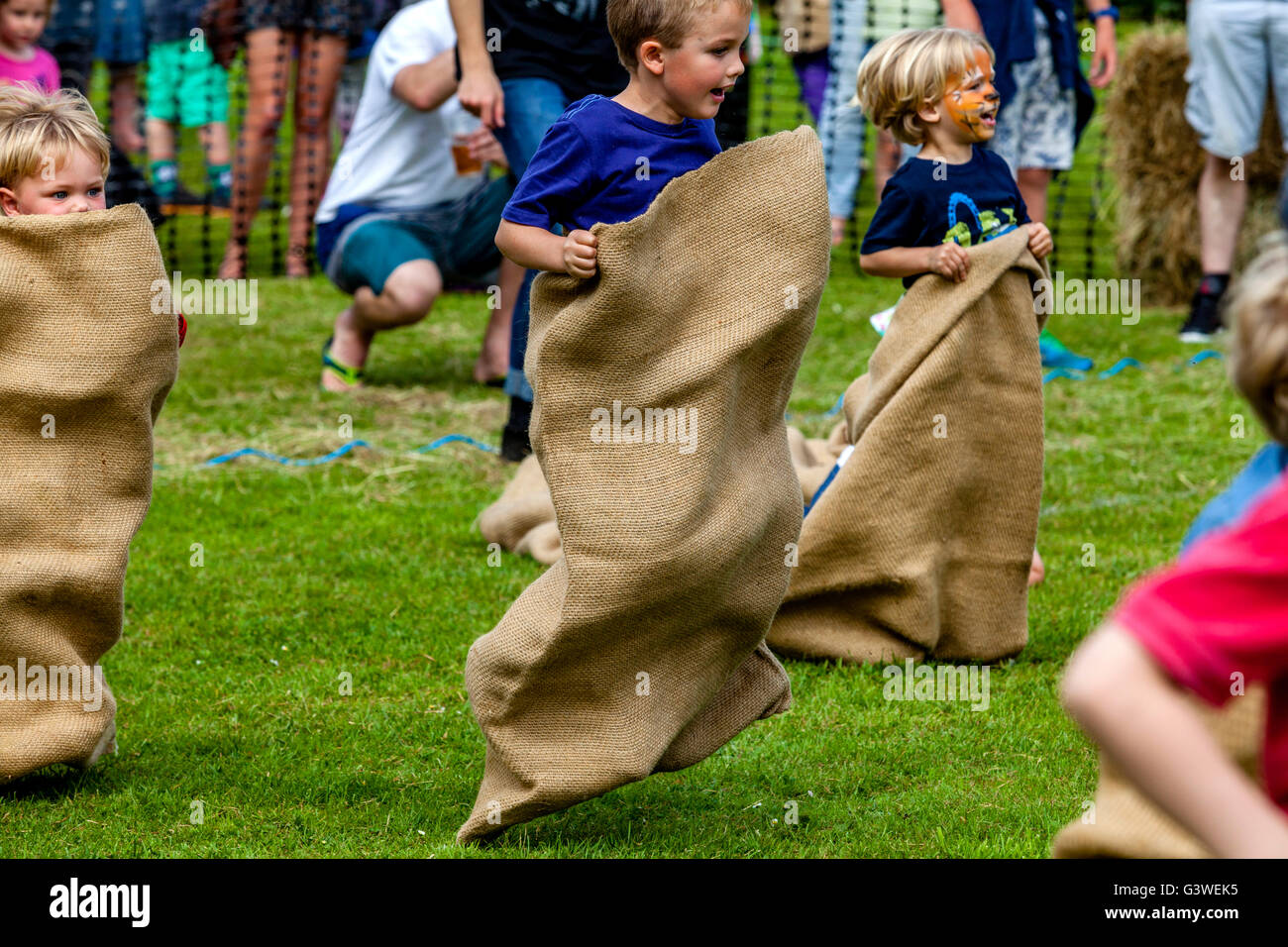 I bambini in gara un sacco tradizionale gara presso la Fiera medievale di Abinger, Surrey, Regno Unito Foto Stock