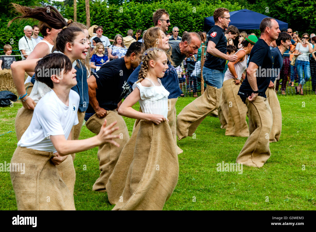 Gli adolescenti e gli adulti in gara un sacco tradizionale gara presso la Fiera medievale di Abinger, Surrey, Regno Unito Foto Stock