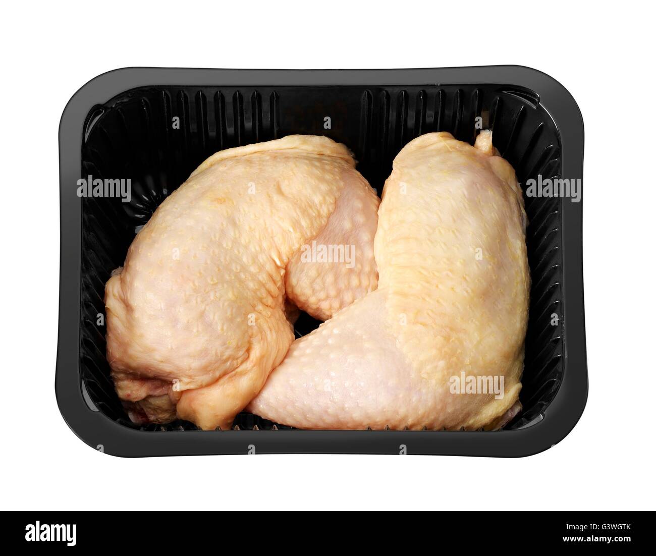Materie le cosce di pollo nel tray nero isolato su bianco Foto Stock