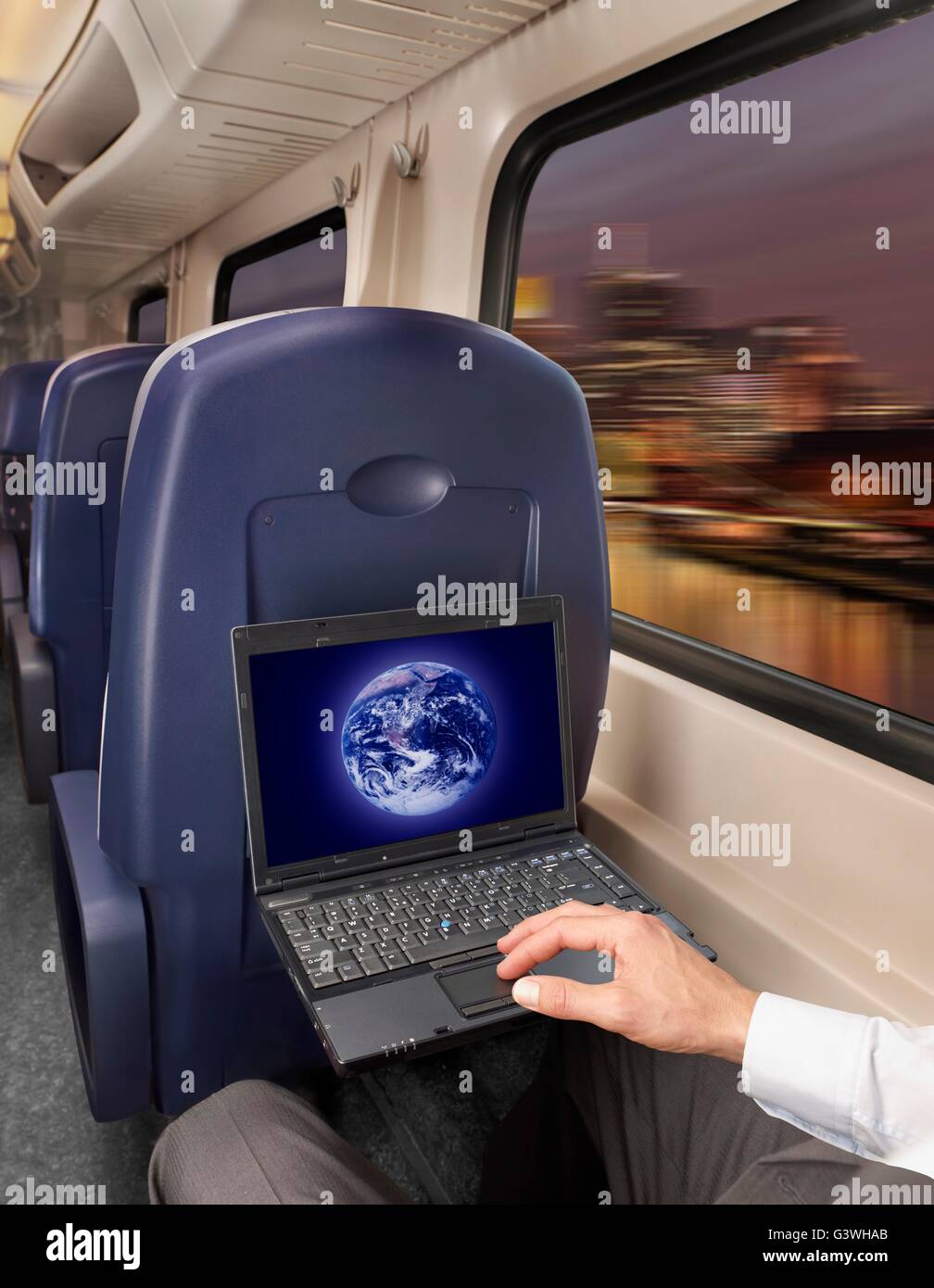 Uomo al lavoro su un computer portatile in treno Foto Stock