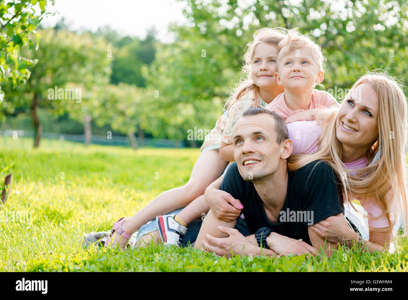 Famiglia giovane giacente su erba in campagna Foto Stock