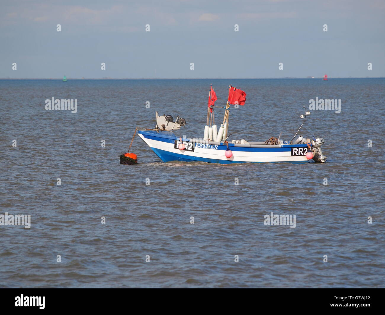 Di piccole dimensioni e di colore bianco e blu barca da pesca su un ormeggio fuori Sheerness. Foto Stock
