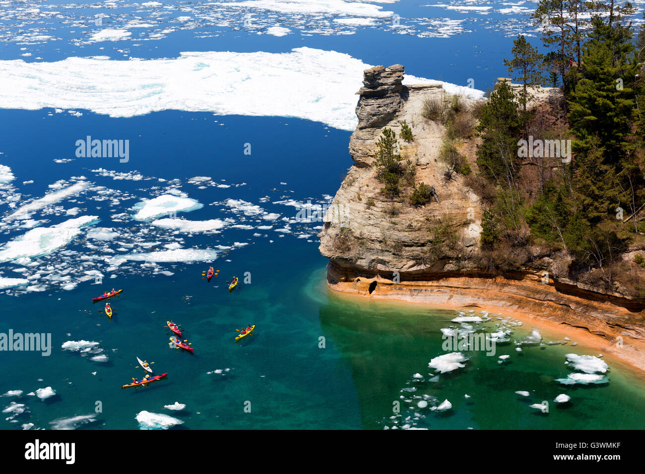 Kayak manovra tramite ice floes per visualizzare i minatori Castle rock formazione sul Lago Superiore. Un ritardo di scioglimento del ghiaccio Foto Stock