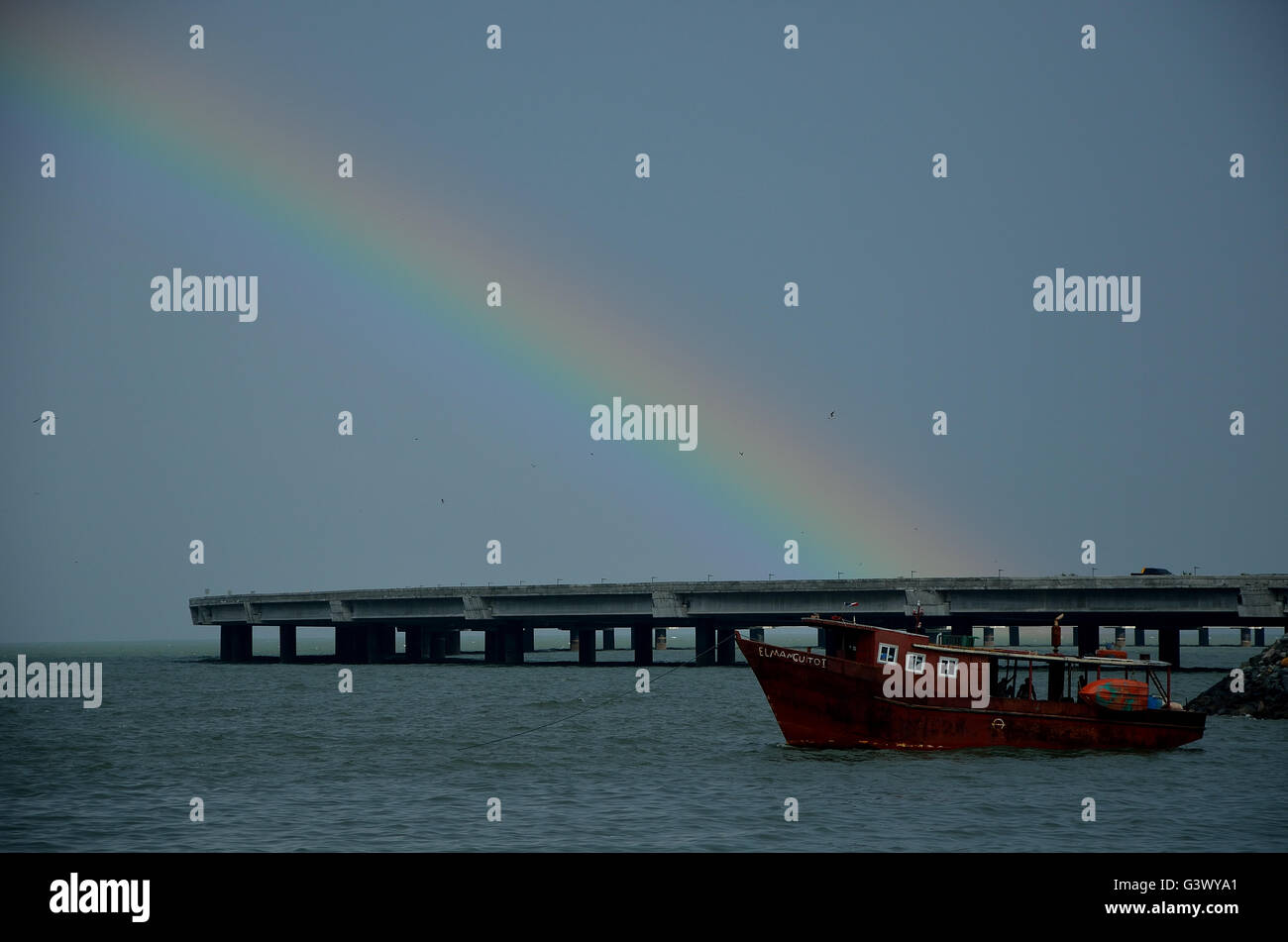 Una barca di soddisfare un arcobaleno in Panama City's Beach. Nazioni Unite barco de Encontro biella arcoiris onu en playa de ciudad de panama. Foto Stock
