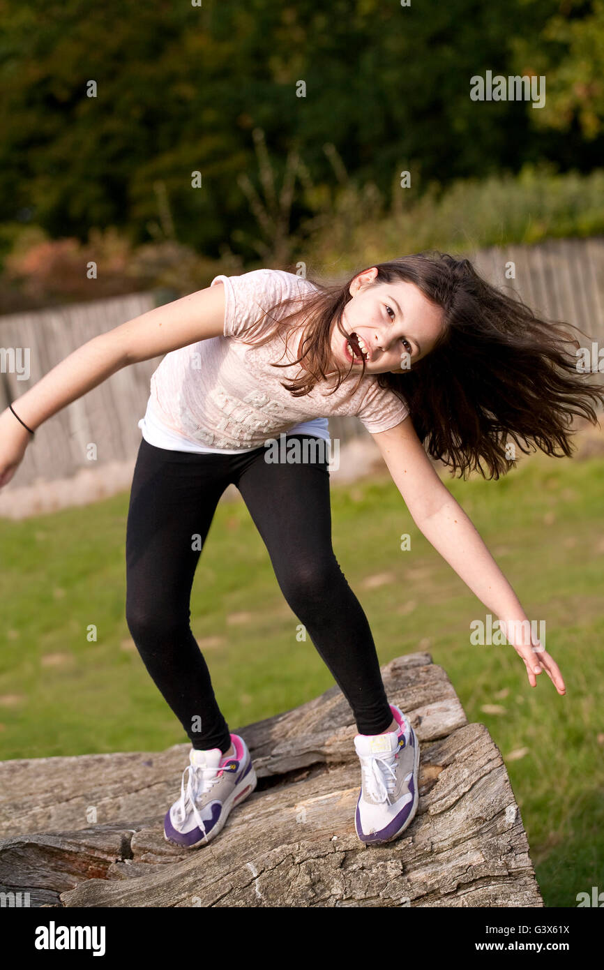 Le ragazze vogliono semplicemente divertirsi. Una giovane ragazza sta giocando boisterously, scaricarsi nel parco e divertirsi. Foto Stock