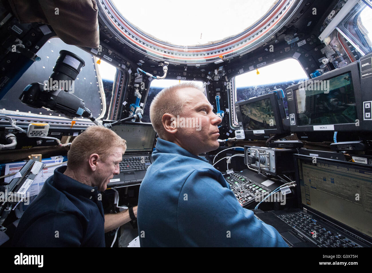 Stazione Spaziale Internazionale Expedition 47 astronauta della NASA Tim Kopra, destra e l'astronauta dell'ESA Timothy Peake utilizzare il Canadarm2 braccio robotico per catturare e dock l'orbitale ATK Cygnus cargo veicolo al modulo Unity Marzo 26, 2016 in orbita intorno alla terra. Foto Stock