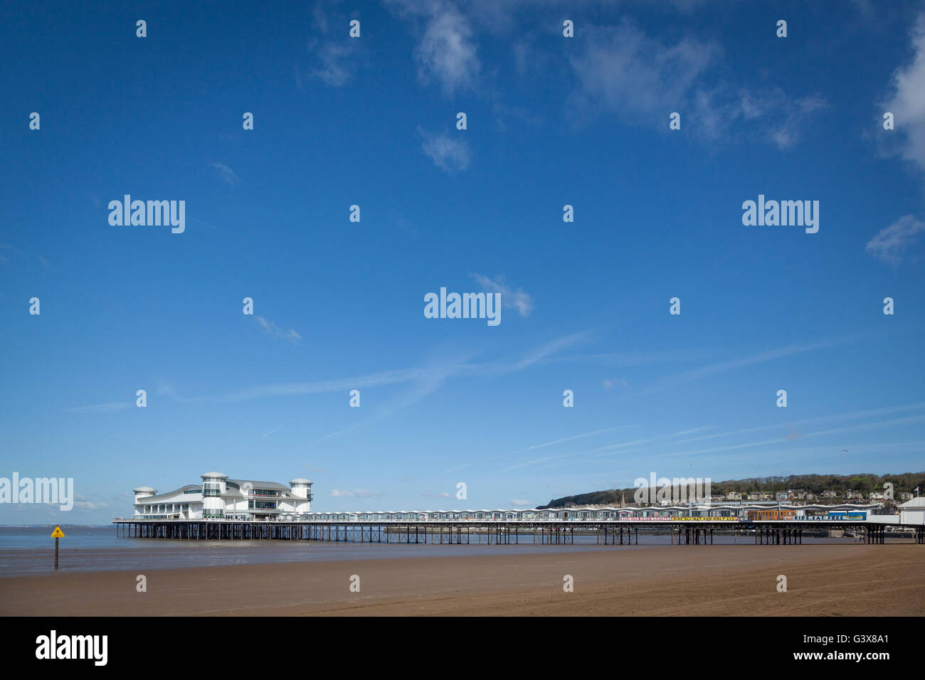 Il Grand Pier sul lungomare di Weston-Super-Mare a bassa marea con la spiaggia di sabbia in una giornata di sole con cielo blu. Foto Stock