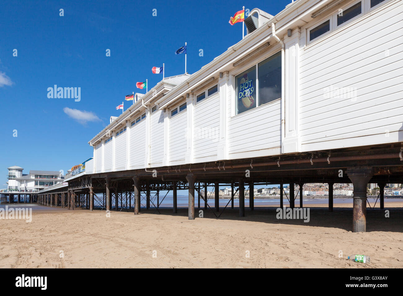 Il Grand Pier sul lungomare di Weston-Super-Mare a bassa marea con la spiaggia di sabbia in una giornata di sole con cielo blu. Foto Stock