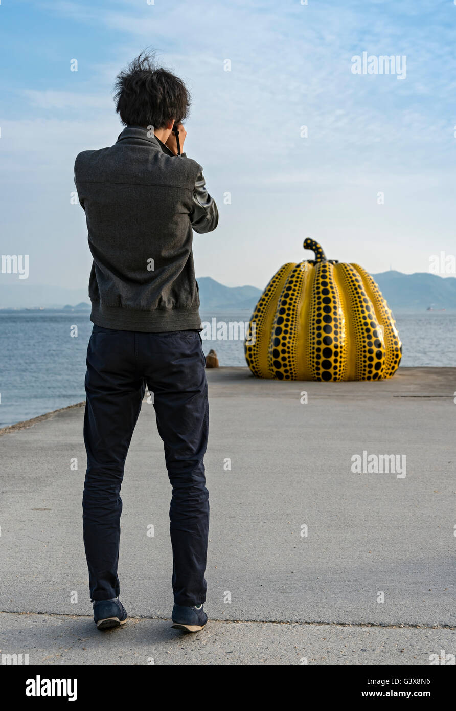 Turista giapponese prende una foto di zucca gialla di Yayoi Kusama, Naoshima, Giappone Foto Stock