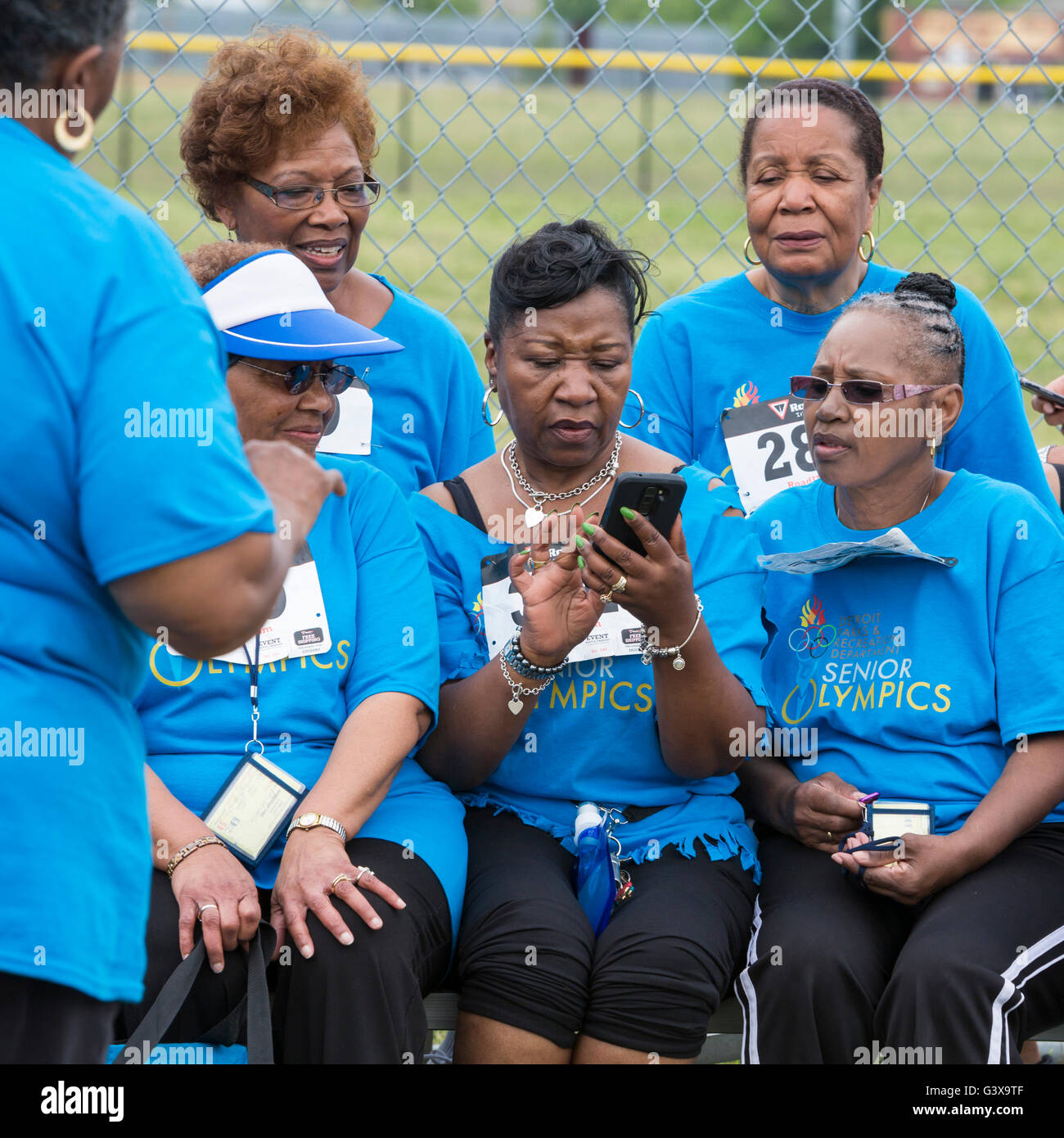 Detroit, Michigan - Le donne lo studio di un telefono cellulare mentre si è in attesa di un evento per iniziare a Detroit Senior Olimpiadi. Foto Stock