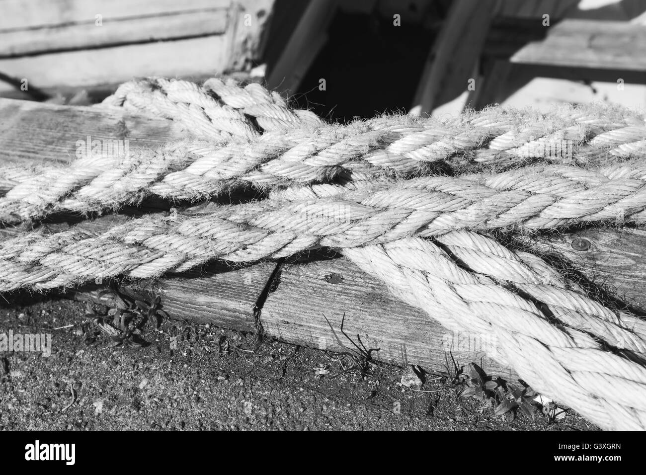 Funi nautico utilizzato per le operazioni di ormeggio giaceva sul molo, closeup foto in bianco e nero con il fuoco selettivo Foto Stock