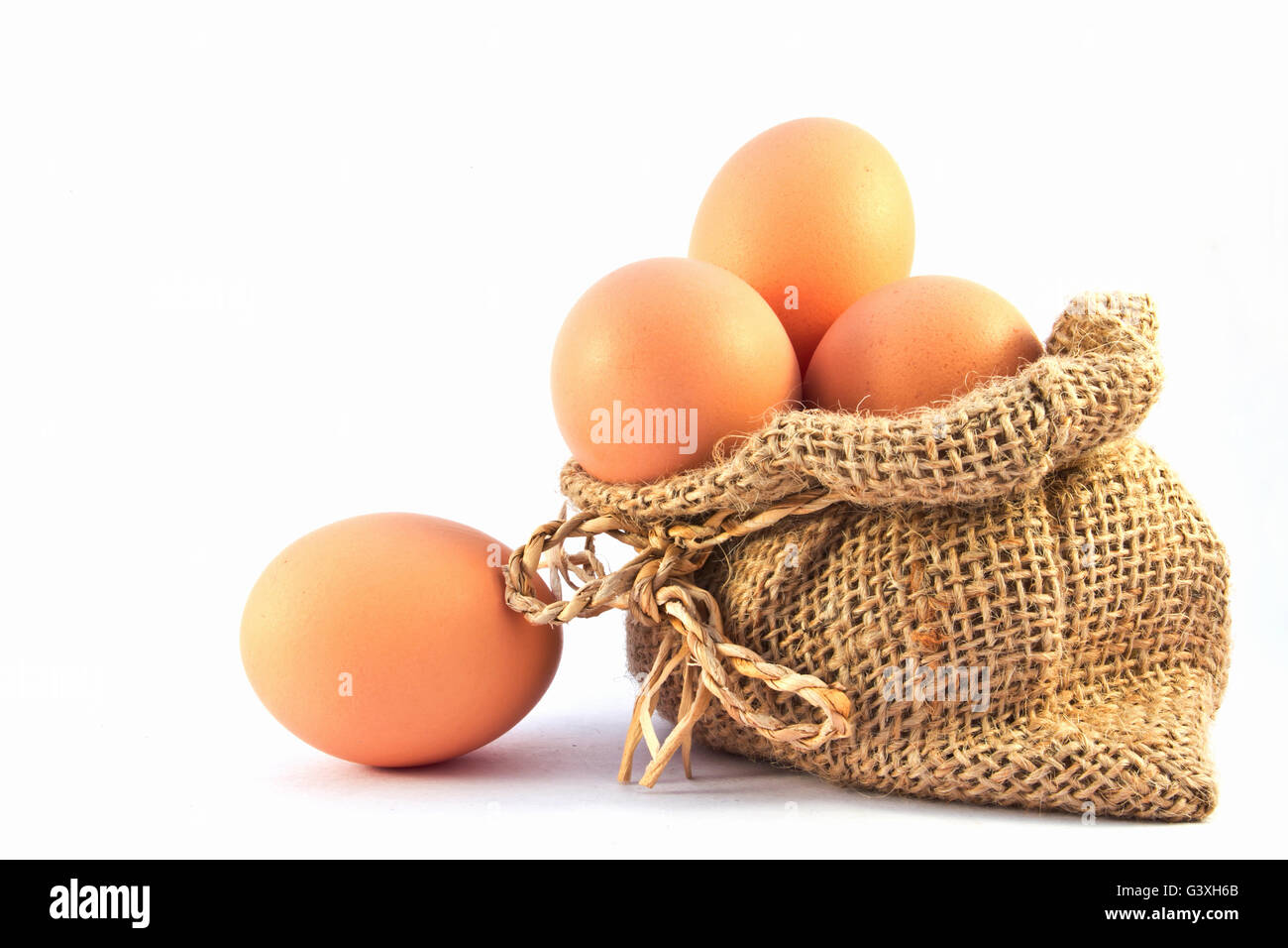 Uova di colore marrone nel sacco di tela isolata su uno sfondo bianco Foto Stock