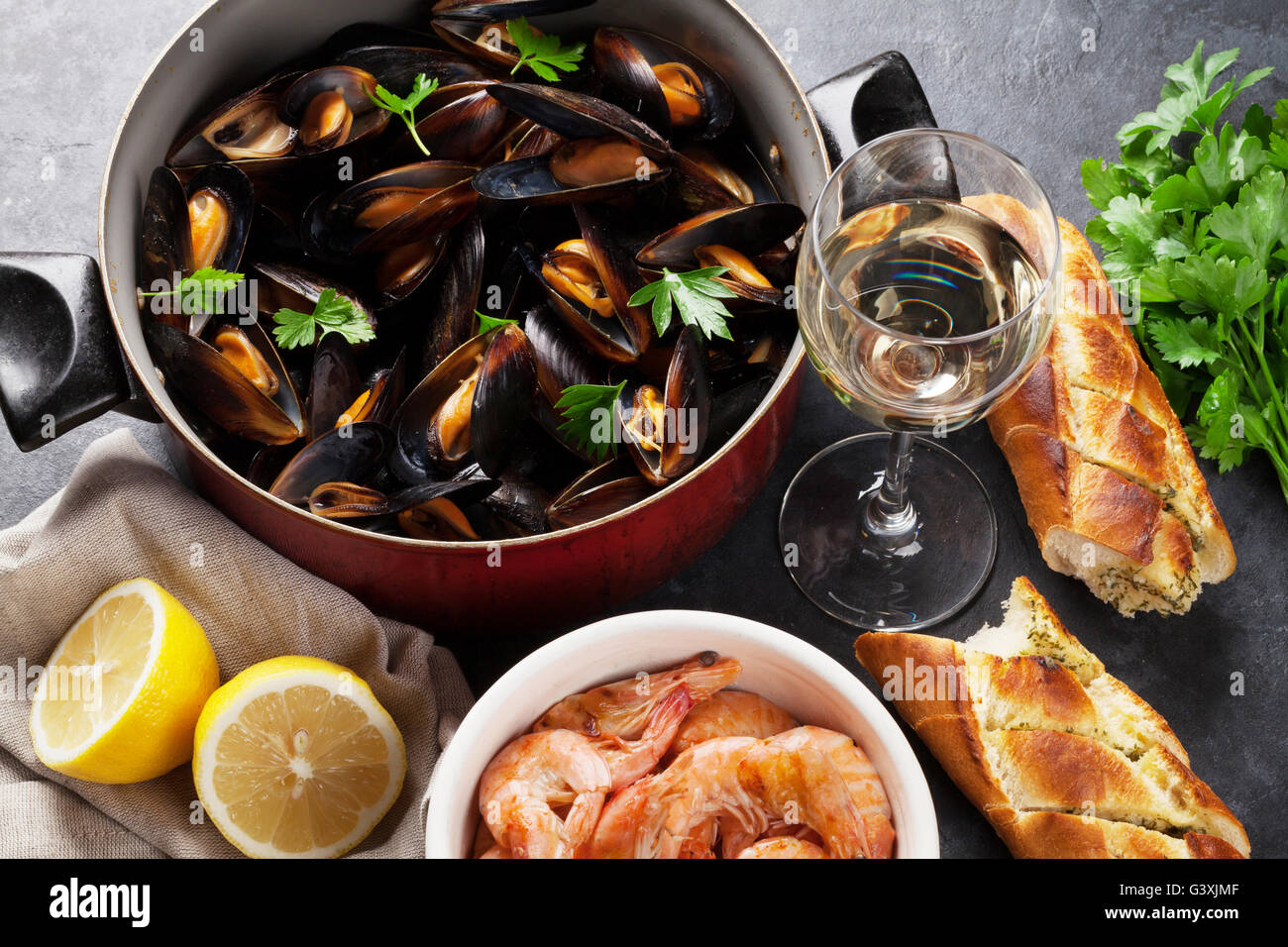 Cozze, Gamberi e vino bianco sul tavolo di pietra Foto Stock