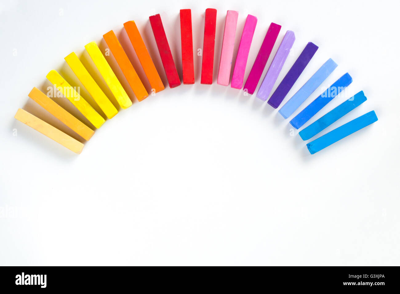 Arcobaleno di gessi colorati schierate arrotondato sul cerchio su sfondo bianco Foto Stock