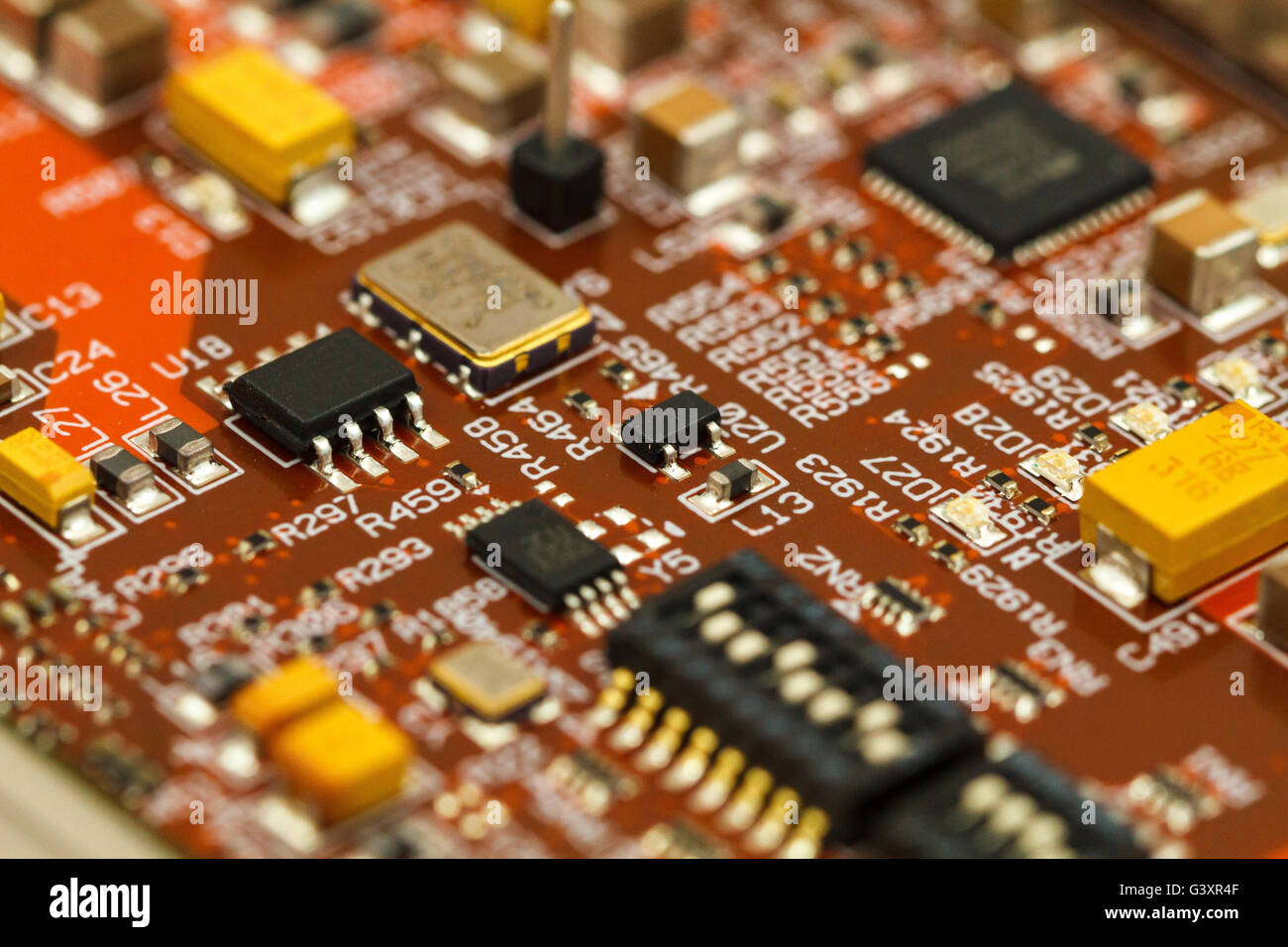 Scheda a circuito stampato con ICs, condensatori a chip al tantalio, condensatori e resistori chip. Foto Stock