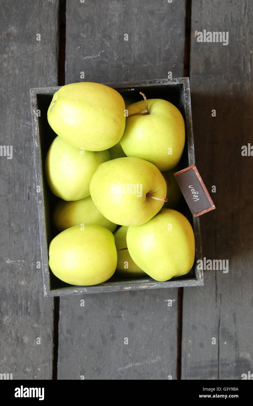 Cibo vegan idea, mele verdi su un vecchio tavolo Foto Stock