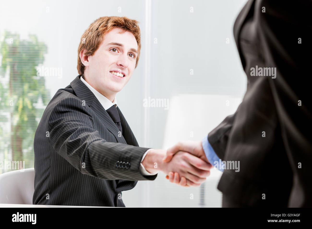 Sorridente uomo d affari o lavoratore di ufficio agitando la mano di un altro imprenditore Foto Stock