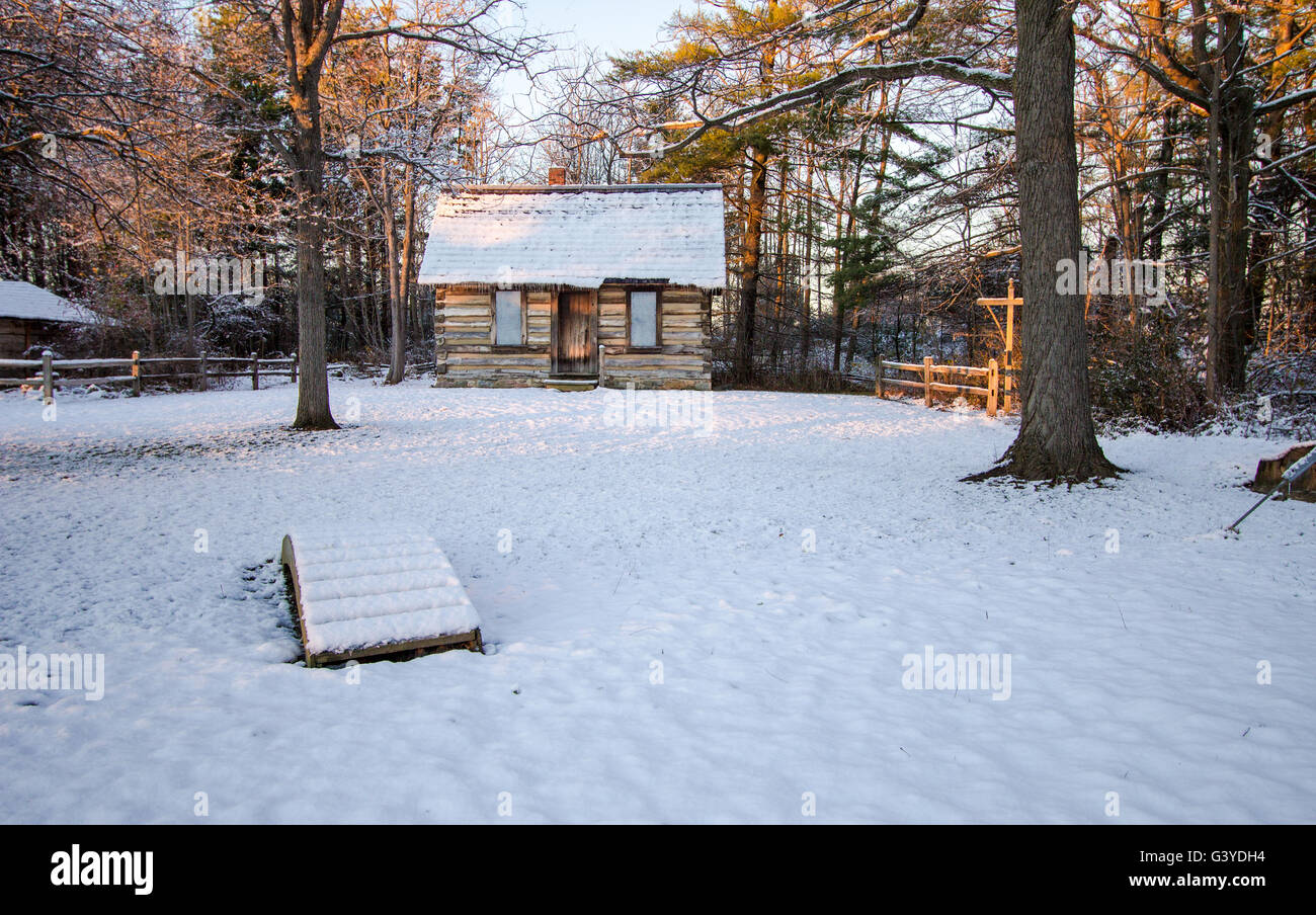 Cabina invernale nei boschi. Coperta di neve accogliente log cabin in un invernale foresta settentrionale. Foto Stock