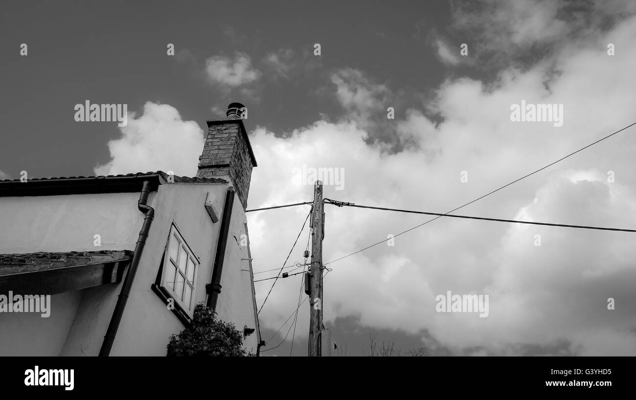 Antico casolare che mostra un allarme installato insieme al sistema con un nuovo cablaggio eretto su un polo utilità. Foto Stock