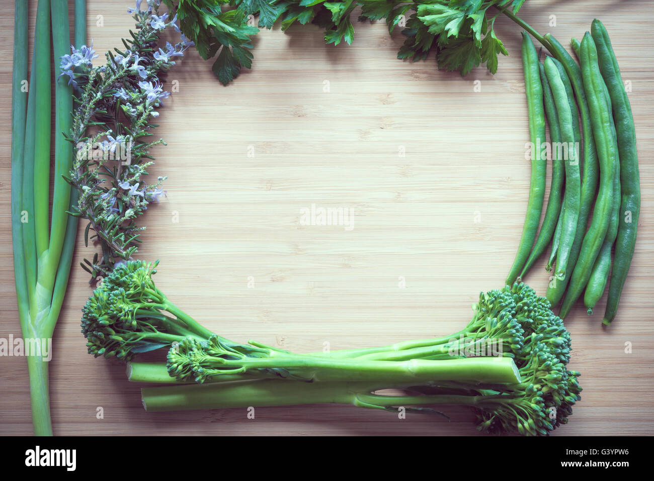 Piano superiore vista laici di fresche verdure organiche sul tagliere di legno con copyspace. Color-tonificante effetto applicato. Foto Stock