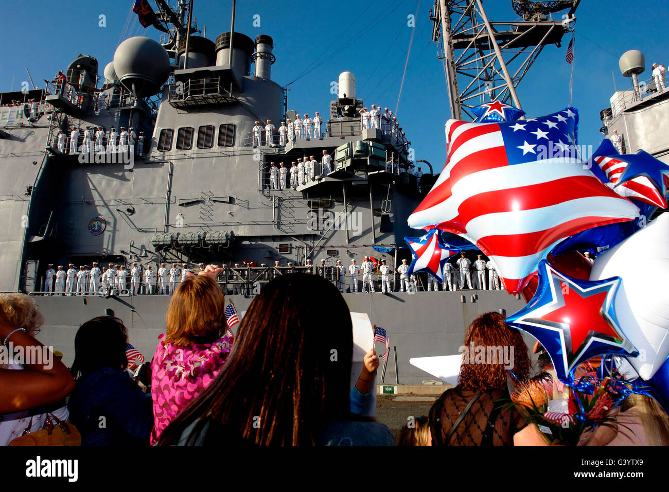 I membri della famiglia attendere sul molo come il missile cruiser USS Chosin torna a Pearl Harbor. Foto Stock