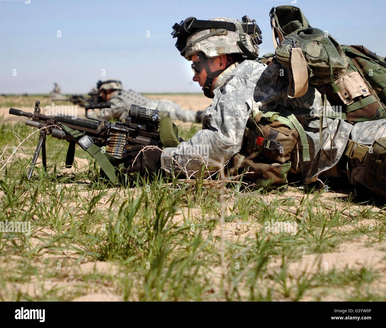 Un U.S. Army soldier guarda al prossimo obiettivo da dietro il suo M240B mitragliatrice. Foto Stock