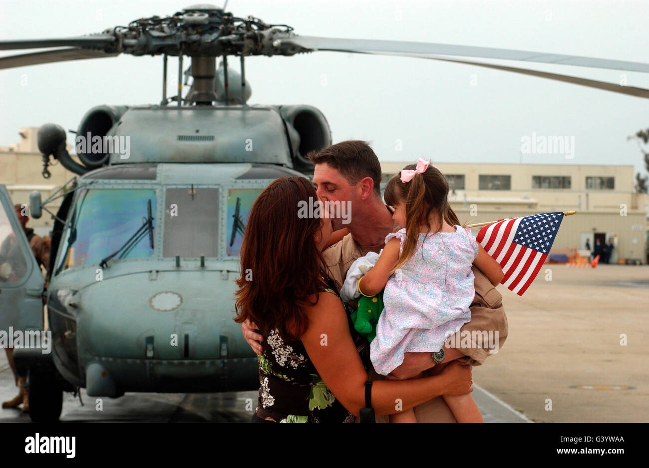 Un funzionario abbraccia la moglie e la figlia. Foto Stock