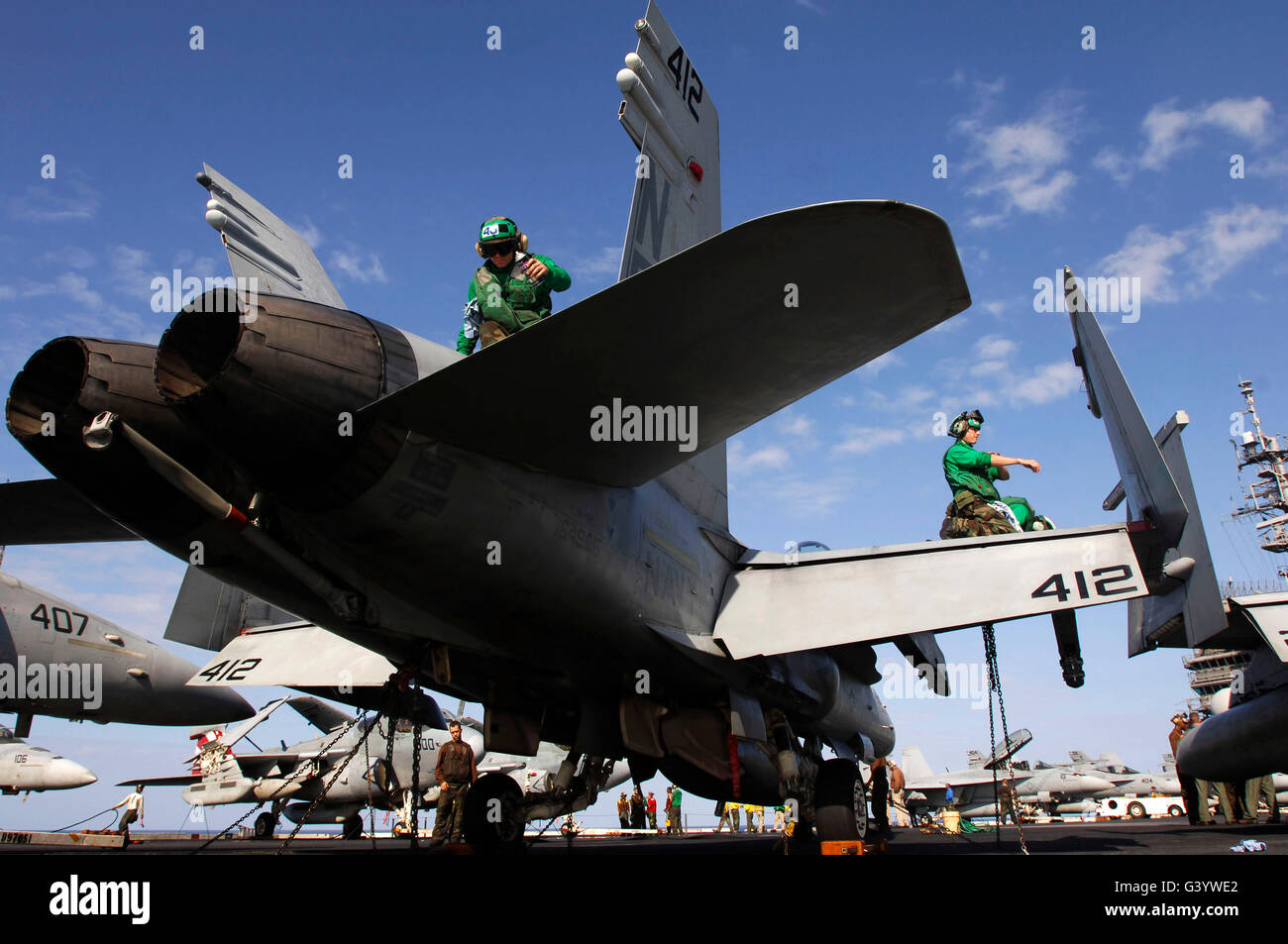 I marinai strofinare un F/A-18 Hornet a bordo della USS Kitty Hawk. Foto Stock