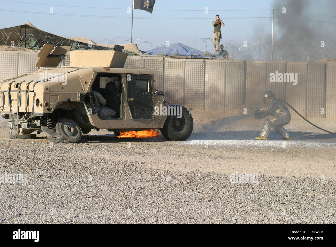 Firefighter mette fuori le fiamme su un Humvee durante la simulazione di una esplosione. Foto Stock