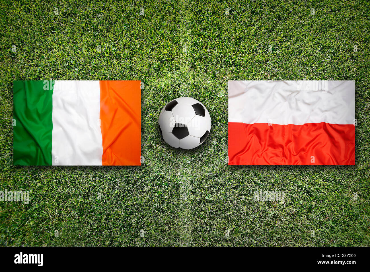 Irlanda vs Polonia bandiere sul verde del campo di calcio Foto Stock
